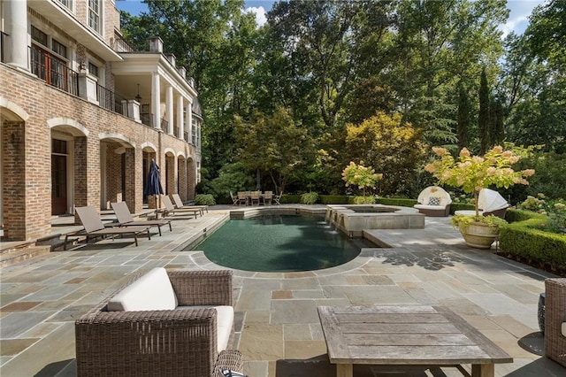 view of pool with a patio and a pool with connected hot tub