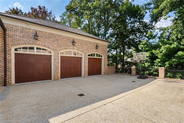 garage with driveway and fence