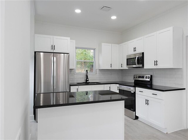 1097 Hubbard St SW, Atlanta, GA 30310 - kitchen with crown molding, sink, white cabinets, and appliances with stainless steel finishes