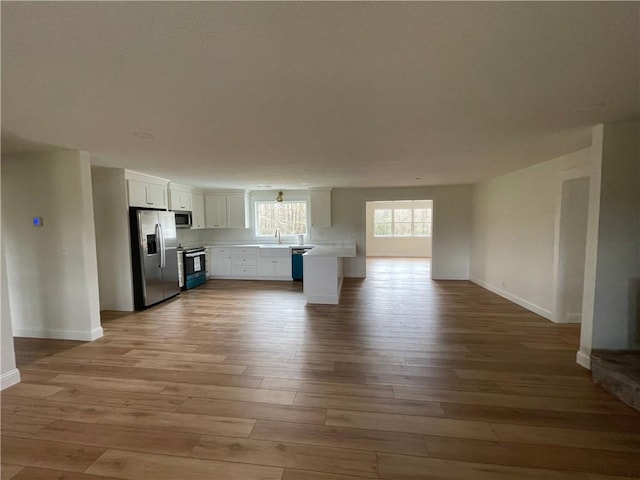 446 Brown Bridge Rd, Chatsworth, GA 30705 - kitchen featuring stainless steel appliances, open floor plan, wood finished floors, baseboards, and light countertops