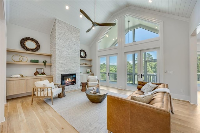 5651 Old Wilkie Rd, Gainesville, GA 30506 - living area featuring a stone fireplace, light wood-style flooring, a ceiling fan, high vaulted ceiling, and built in shelves