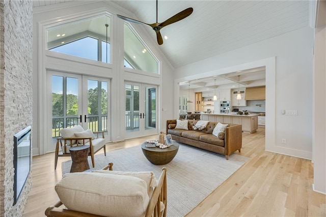 5651 Old Wilkie Rd, Gainesville, GA 30506 - living room featuring a ceiling fan, light wood finished floors, french doors, a stone fireplace, and high vaulted ceiling