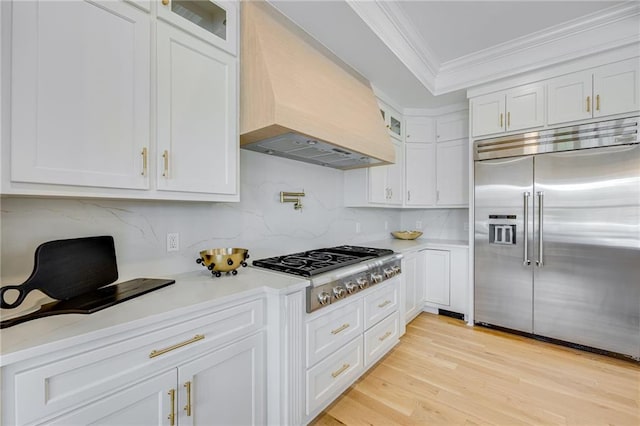 5651 Old Wilkie Rd, Gainesville, GA 30506 - kitchen featuring appliances with stainless steel finishes, custom range hood, ornamental molding, white cabinets, and light countertops