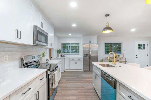 1091 Pine St, Conyers, GA 30012 - kitchen with appliances with stainless steel finishes, light countertops, recessed lighting, white cabinetry, and pendant lighting