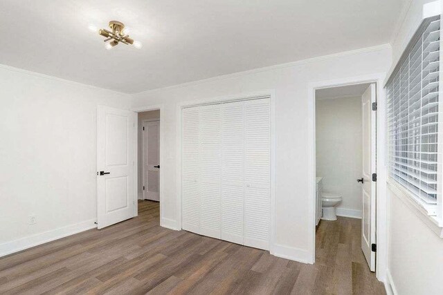 1091 Pine St, Conyers, GA 30012 - unfurnished bedroom featuring wood finished floors, a closet, and ornamental molding