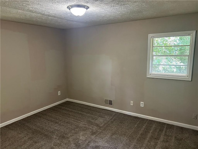 6956 Kimberland Gardens Ln, Lithonia, GA 30058 - spare room featuring a textured ceiling, dark colored carpet, and baseboards