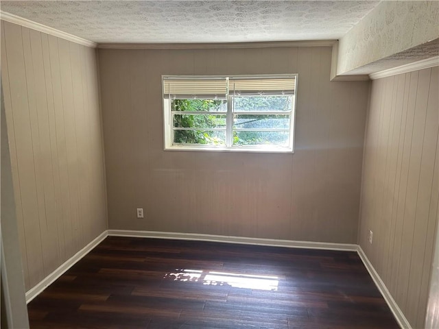 6956 Kimberland Gardens Ln, Lithonia, GA 30058 - empty room with wood finished floors, a textured ceiling, baseboards, wooden walls, and crown molding