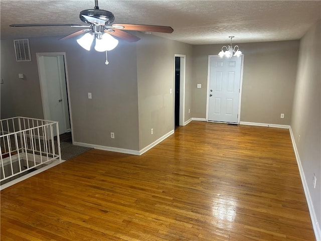 6956 Kimberland Gardens Ln, Lithonia, GA 30058 - unfurnished room featuring a chandelier, baseboards, a textured ceiling, wood finished floors, and a ceiling fan