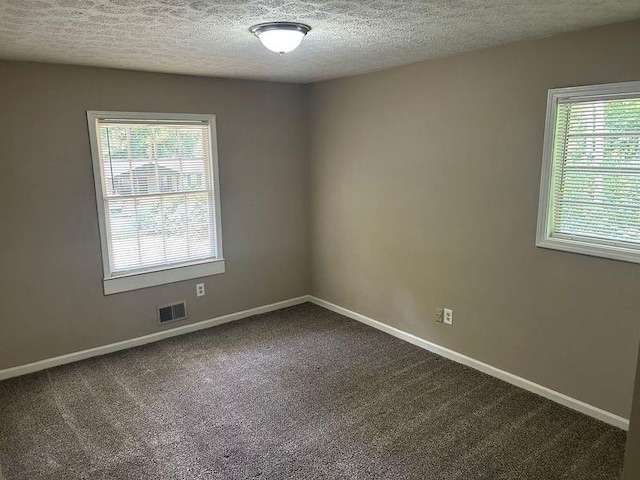 6956 Kimberland Gardens Ln, Lithonia, GA 30058 - empty room with dark carpet, baseboards, and a textured ceiling