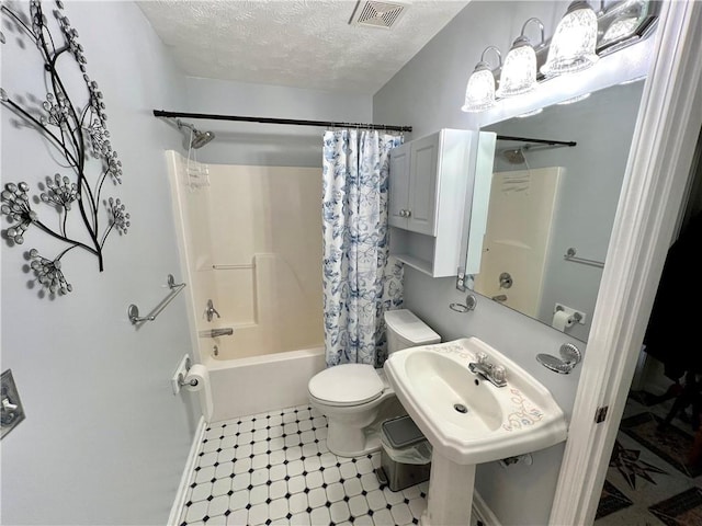 full bathroom featuring sink, shower / bath combination with curtain, a textured ceiling, and toilet