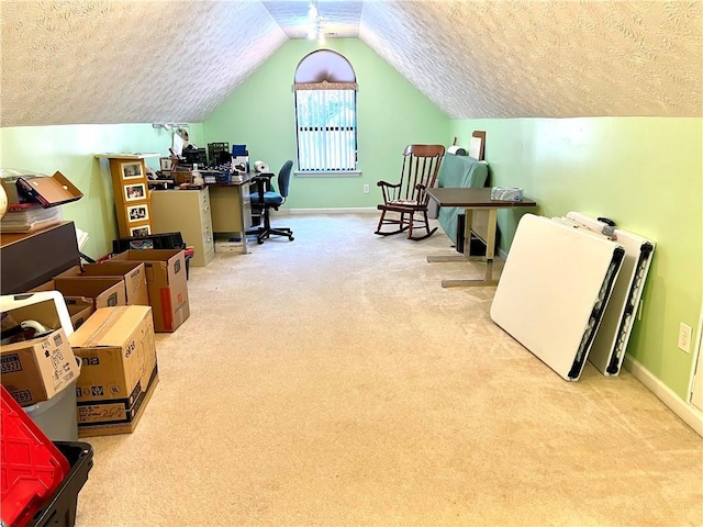 carpeted office featuring lofted ceiling and a textured ceiling