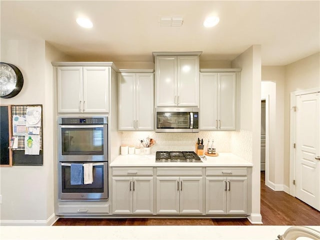 810 Pressing Dr, Alpharetta, GA 30004 - kitchen with stainless steel appliances, backsplash, dark wood-style flooring, light countertops, and baseboards