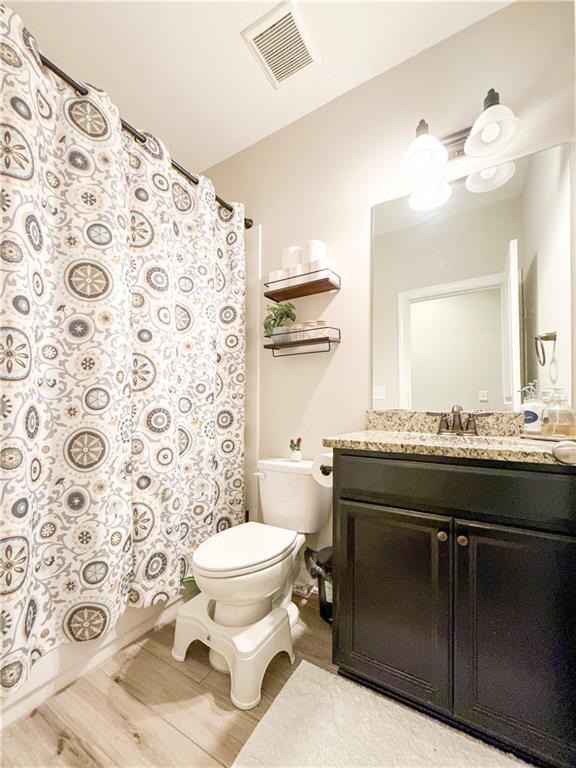 810 Pressing Dr, Alpharetta, GA 30004 - full bathroom with toilet, vanity, a shower with shower curtain, and wood finished floors