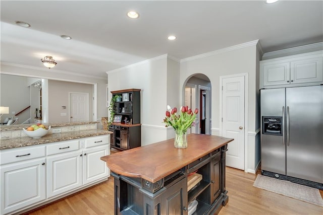 kitchen featuring light hardwood / wood-style flooring, white cabinets, crown molding, a center island, and stainless steel fridge with ice dispenser