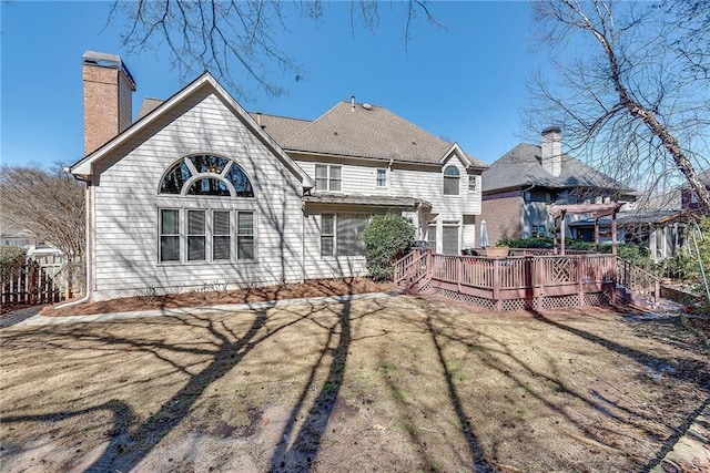 rear view of property featuring a yard and a wooden deck