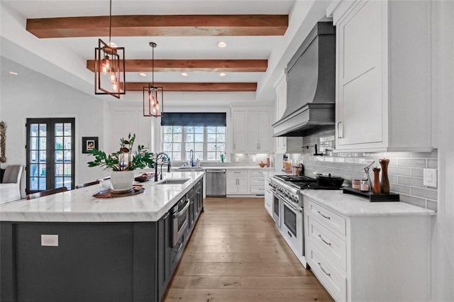 kitchen with stainless steel appliances, beam ceiling, a sink, and custom range hood