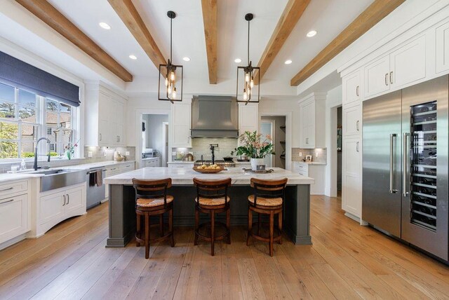 1530 Redd Rd, Milton, GA 30004 - kitchen featuring white cabinets, wine cooler, a sink, a center island with sink, and beamed ceiling