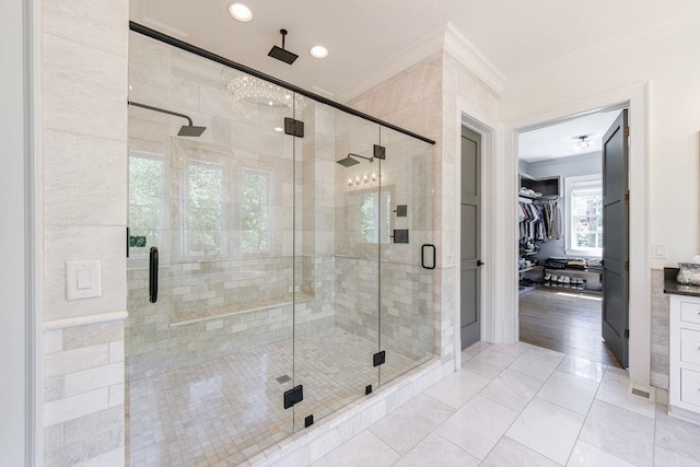 full bath with recessed lighting, a shower stall, a spacious closet, and ornamental molding