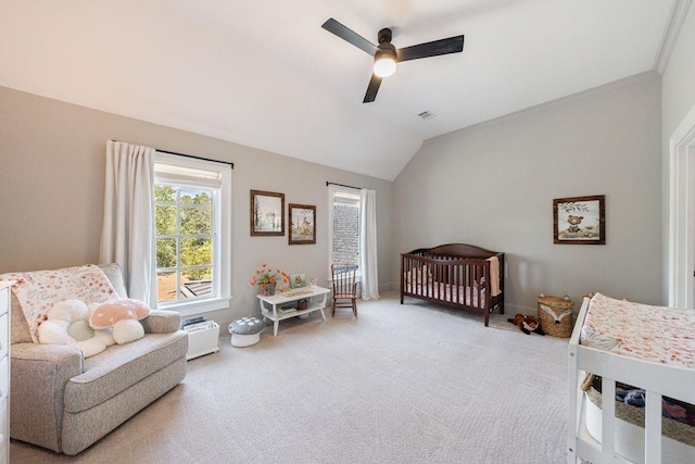 bedroom featuring vaulted ceiling, visible vents, a nursery area, light colored carpet, and ceiling fan
