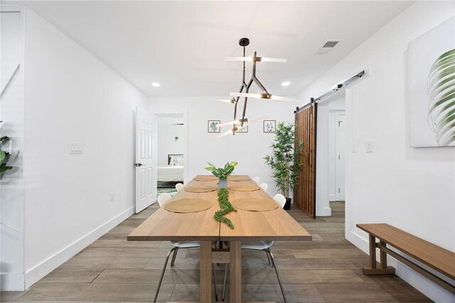 dining room featuring a barn door and wood-type flooring