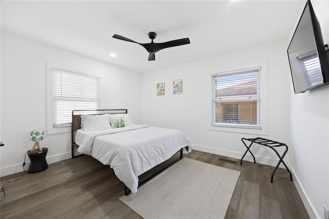 bedroom with multiple windows, ceiling fan, and dark hardwood / wood-style floors