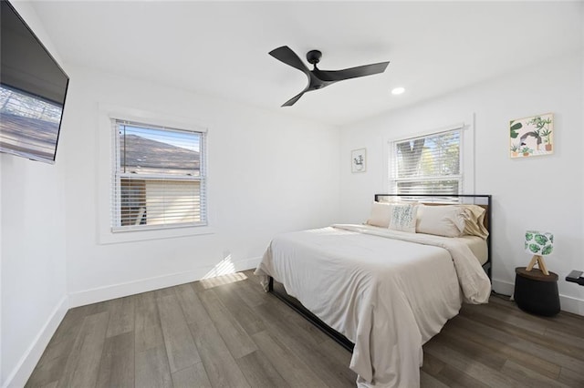 bedroom with multiple windows, ceiling fan, and dark hardwood / wood-style flooring