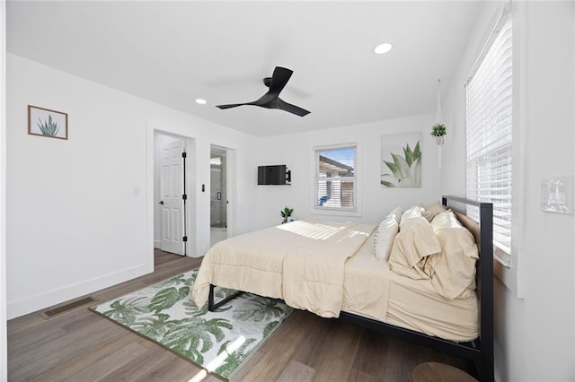 bedroom with hardwood / wood-style floors, connected bathroom, and ceiling fan