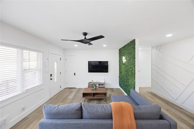 living room featuring ceiling fan and light wood-type flooring