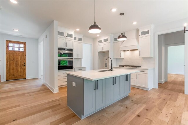 6073 Rockingham Way, Gainesville, GA 30506 - kitchen with white cabinets, stainless steel double oven, a sink, decorative backsplash, and custom exhaust hood
