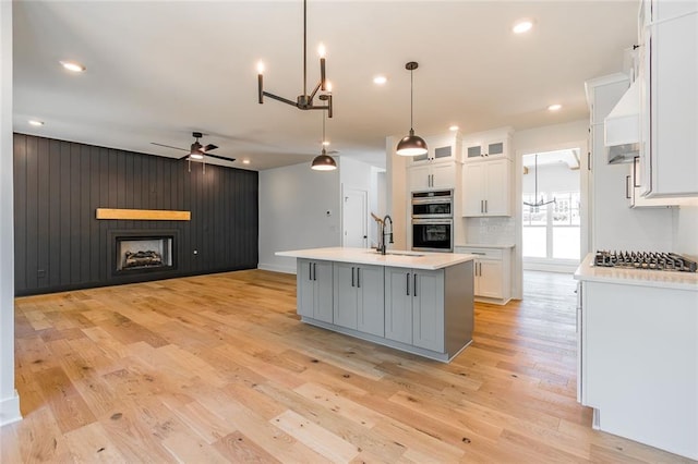 6073 Rockingham Way, Gainesville, GA 30506 - kitchen featuring a sink, light countertops, ceiling fan with notable chandelier, stainless steel appliances, and white cabinetry