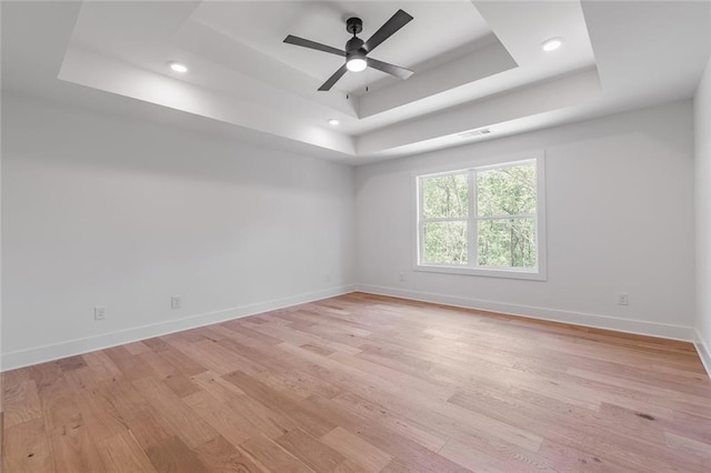 6073 Rockingham Way, Gainesville, GA 30506 - spare room featuring a ceiling fan, visible vents, baseboards, light wood finished floors, and a tray ceiling