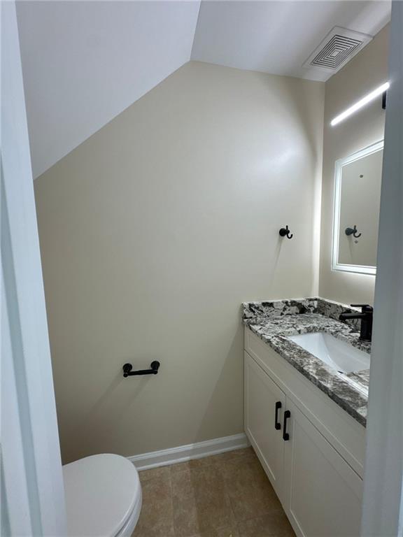 923 Prestwyck Ct, Alpharetta, GA 30004 - half bath with vanity, toilet, baseboards, and lofted ceiling