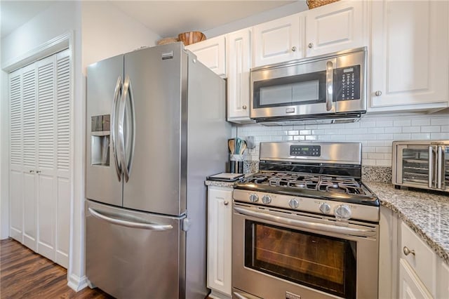 kitchen with decorative backsplash, white cabinetry, and appliances with stainless steel finishes