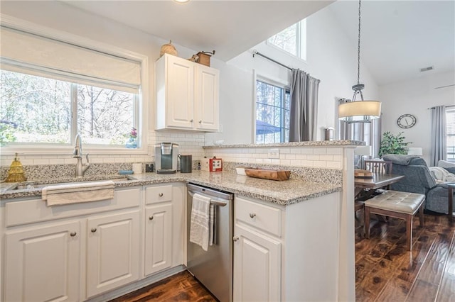 kitchen featuring a sink, white cabinetry, a peninsula, dishwasher, and vaulted ceiling