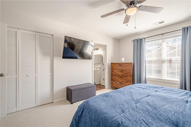 bedroom with a ceiling fan, visible vents, carpet floors, ensuite bath, and a closet