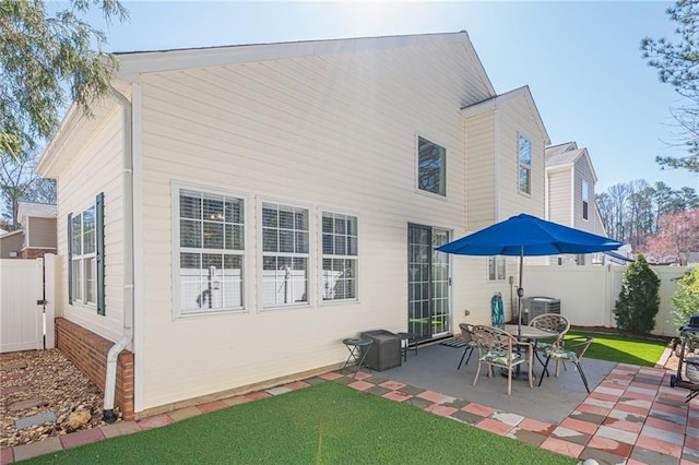 rear view of property with a yard, cooling unit, a patio, and fence