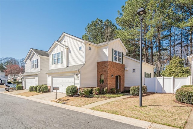 view of front of house with fence, an attached garage, concrete driveway, a front lawn, and brick siding