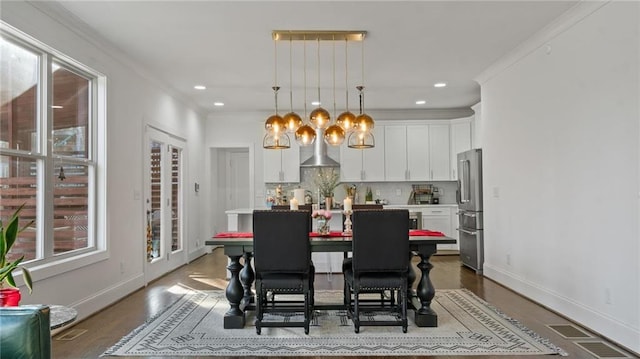 dining room with wood-type flooring and ornamental molding