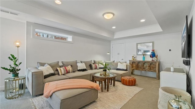 carpeted living room featuring a raised ceiling