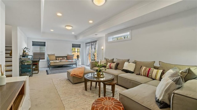 living room featuring a tray ceiling and light colored carpet