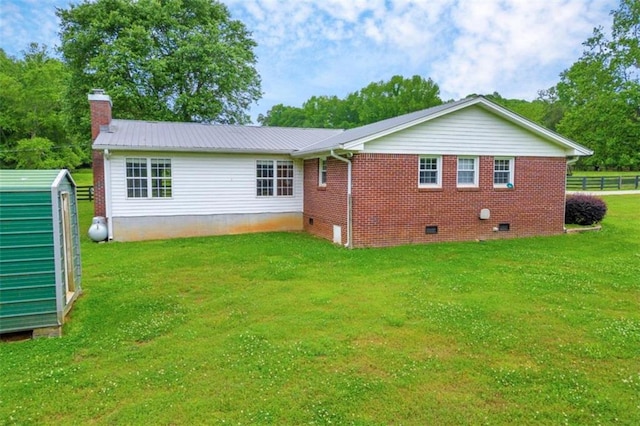 rear view of property with a lawn