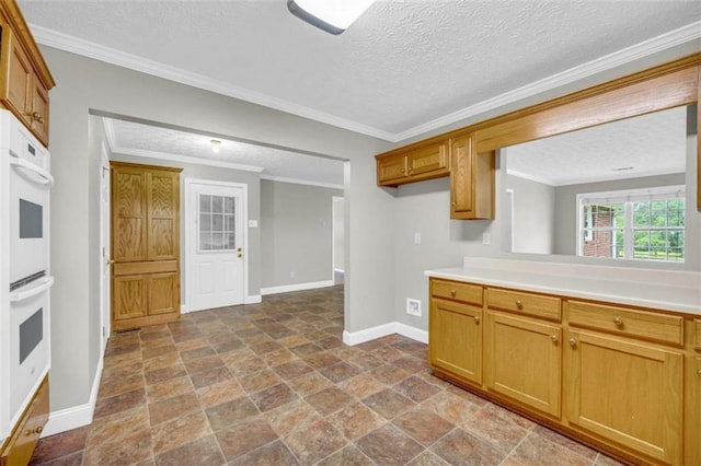 kitchen with tile floors, ornamental molding, a textured ceiling, and double oven