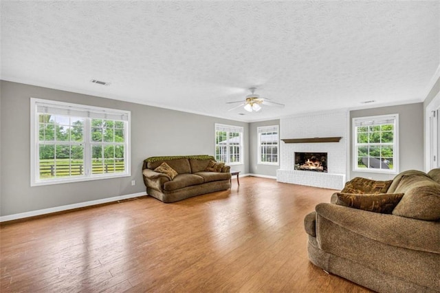 living room with plenty of natural light, a fireplace, and hardwood / wood-style flooring