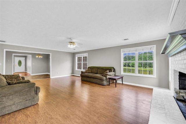 living room with hardwood / wood-style flooring, a fireplace, and crown molding