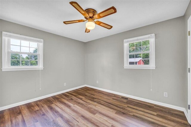 empty room featuring plenty of natural light, ceiling fan, and hardwood / wood-style floors