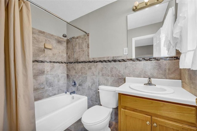 full bathroom featuring tile walls, toilet, tile flooring, shower / bath combo with shower curtain, and vanity