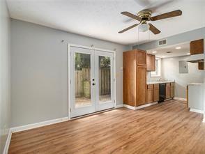 unfurnished living room with french doors, light hardwood / wood-style floors, and ceiling fan