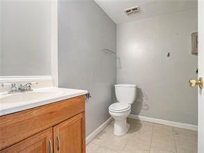 bathroom with tile patterned flooring, vanity, and toilet