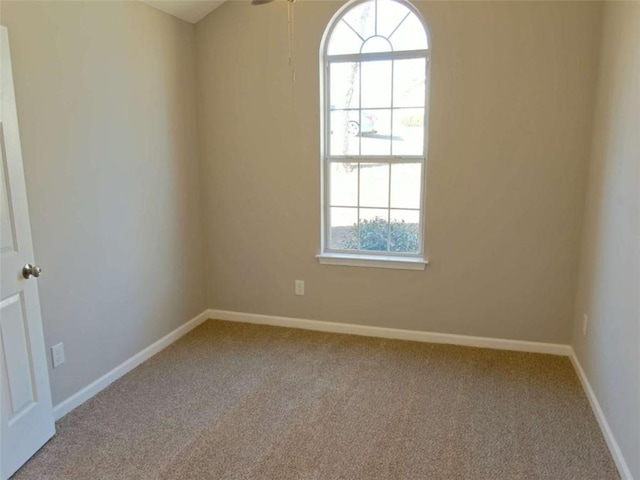 carpeted spare room with baseboards