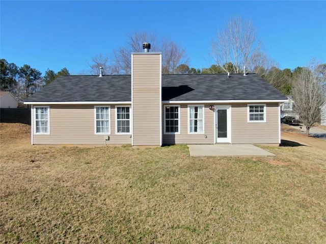 back of house with a chimney, a lawn, and a patio